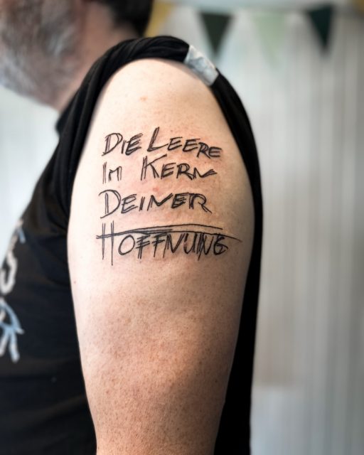 Musik, die unter die Haut geht.

Für Doris und Stoffel durfte ich etwas ganz Besonderes stechen – direkt auf die Haut, frisch und klar:
Doris trägt das Logo ihrer Band,
Stoffel den Bandnamen „Die Leere im Kern deiner Hoffnung“ in der Original-Schriftart.

Zwei Motive, zwei Menschen, eine gemeinsame Geschichte.
Ich liebe es, wenn Tattoos nicht nur gut aussehen, sondern Bedeutung tragen – etwas, das verbindet, sichtbar bleibt und eine Botschaft in sich trägt.
Vielen Dank für euer Vertrauen in meine Arbeit! 🤗

Musik ist Kunst.
Und Kunst darf unter die Haut.

Würdet ihr euch euer Herzensprojekt tätowieren lassen? Oder habt ihr schon eins? 💬👇

#bandtattoo #schriftzugtattoo #finelinetattoo #nippes #atelierherbariumbynuui