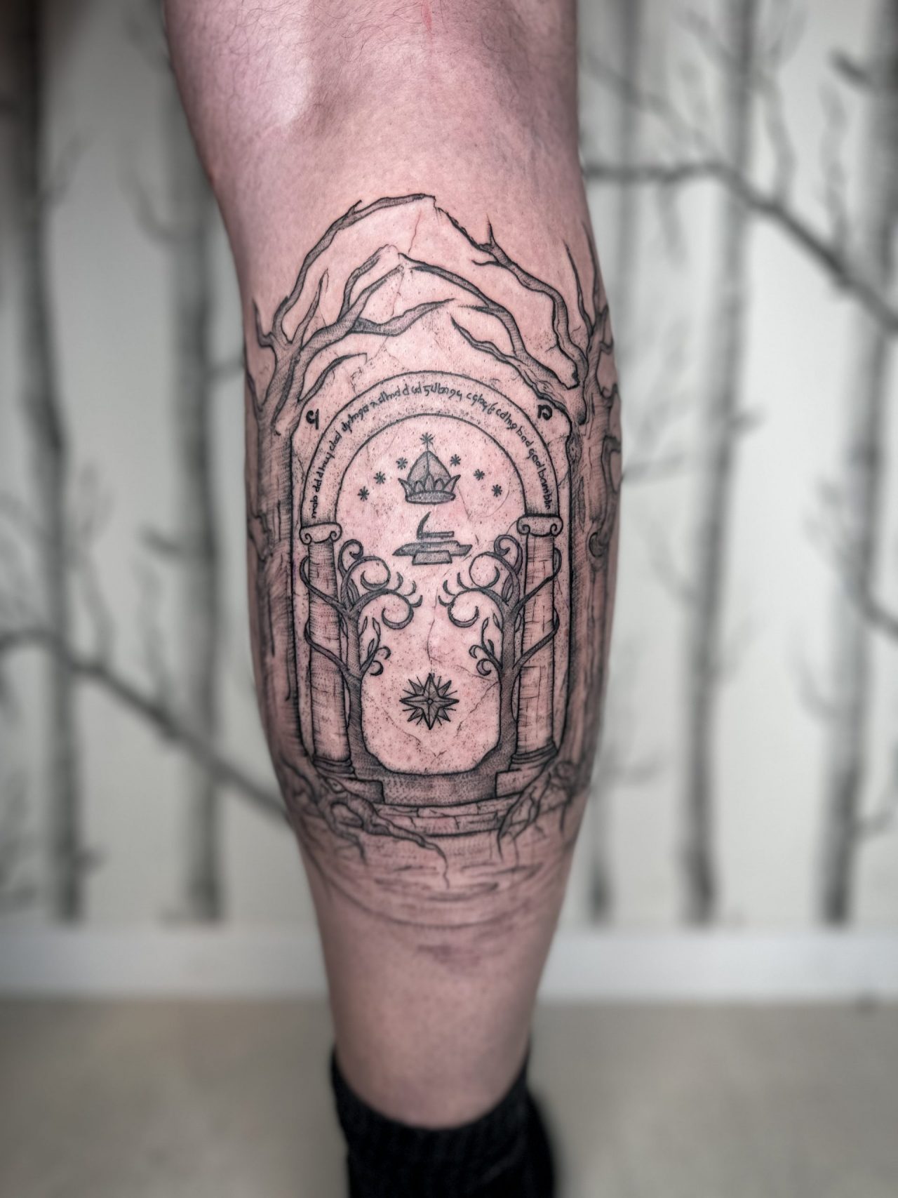 Fantattoo auf der Wade: Tür von Durin aus Herr der Ringe umrandet von Bäumen
