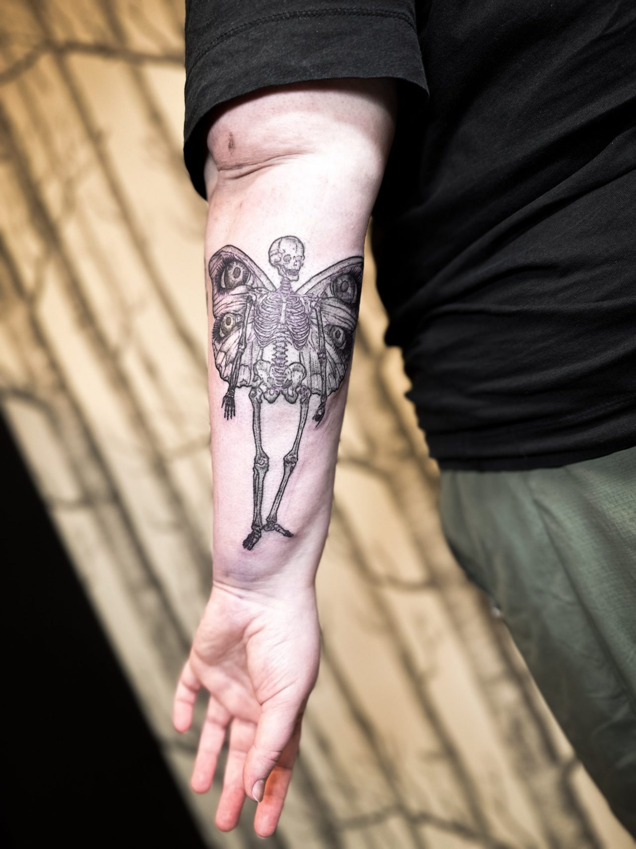 Unterarmtattoo: Skelett mit Schmetterlingsflügeln
