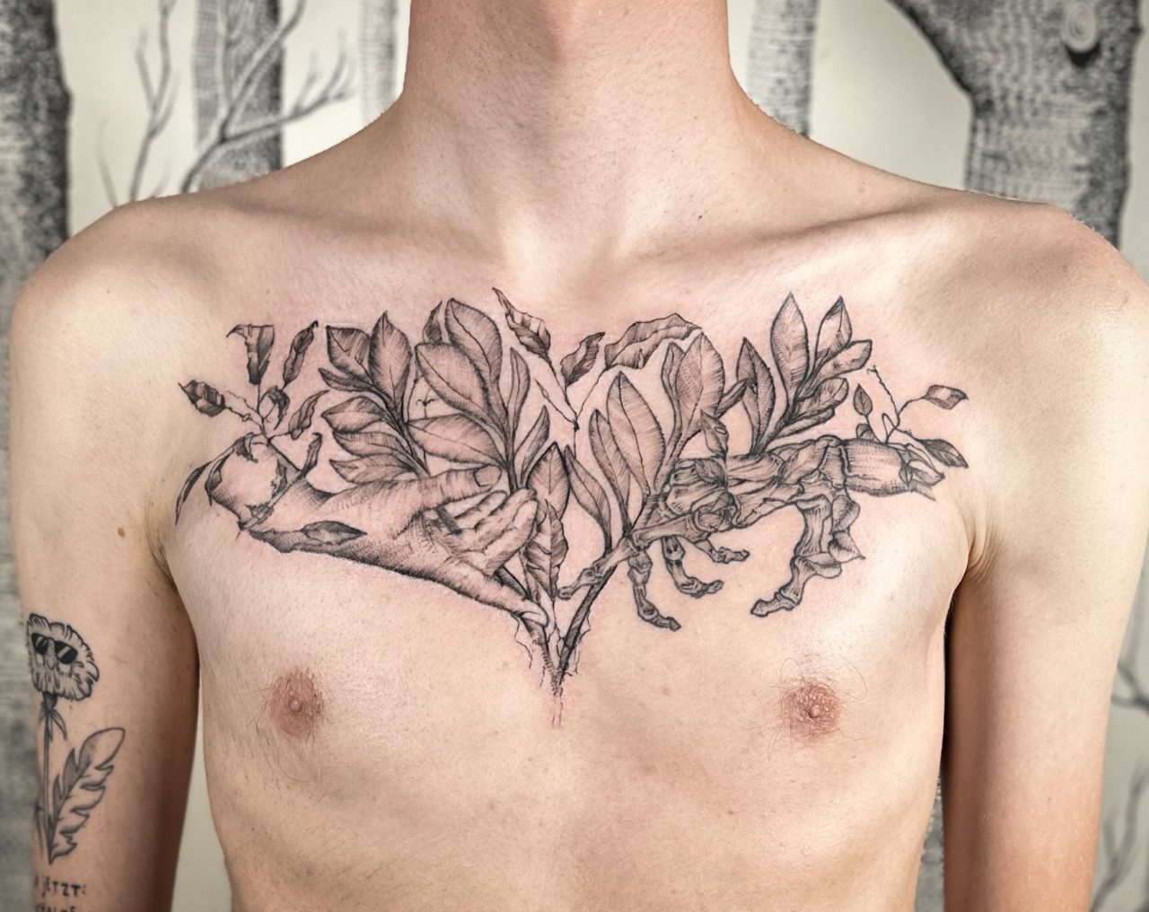 lebende und tote Hand/Skelett berühren sich zwischen Blättern, Tattoo auf Brust