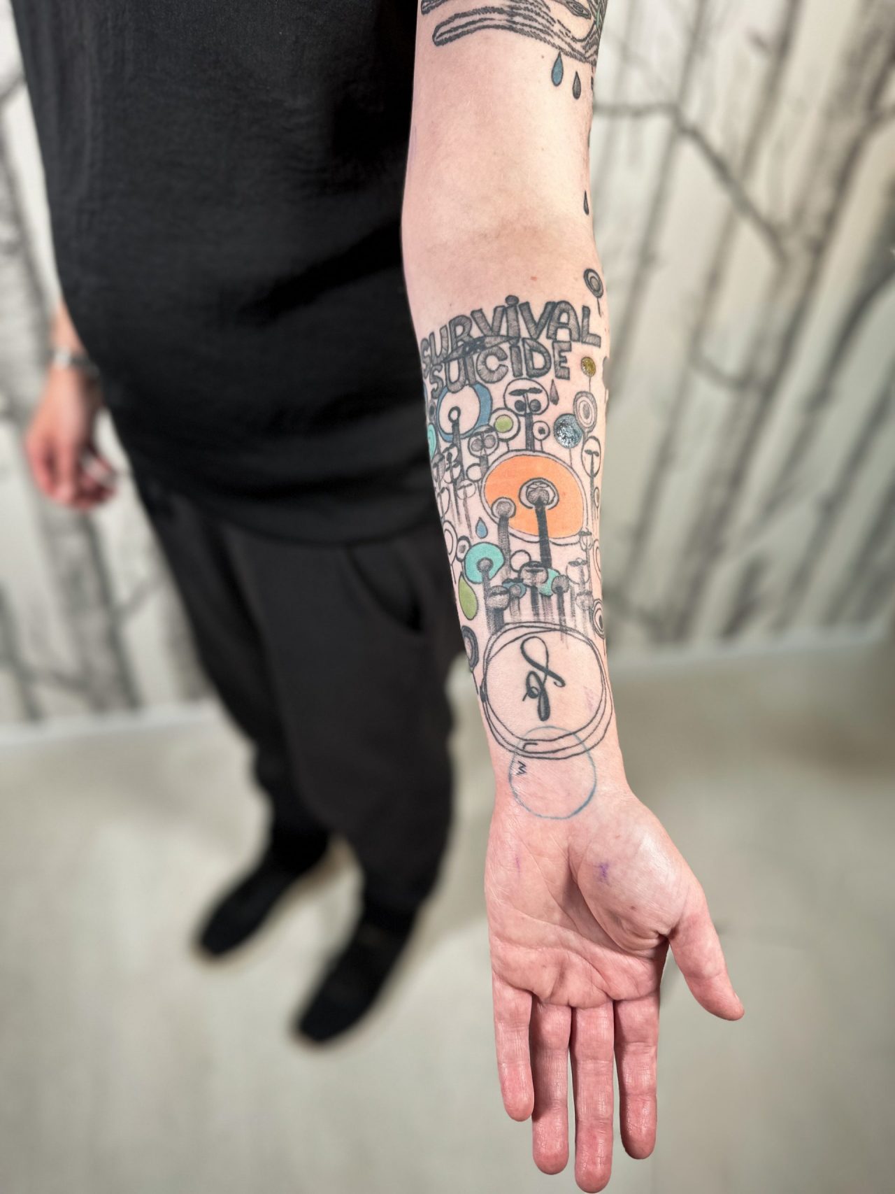 Unterarmtattoo: Lollibäume nach Hundertwasser mit Schriftzug "Survival Suicide", farbig