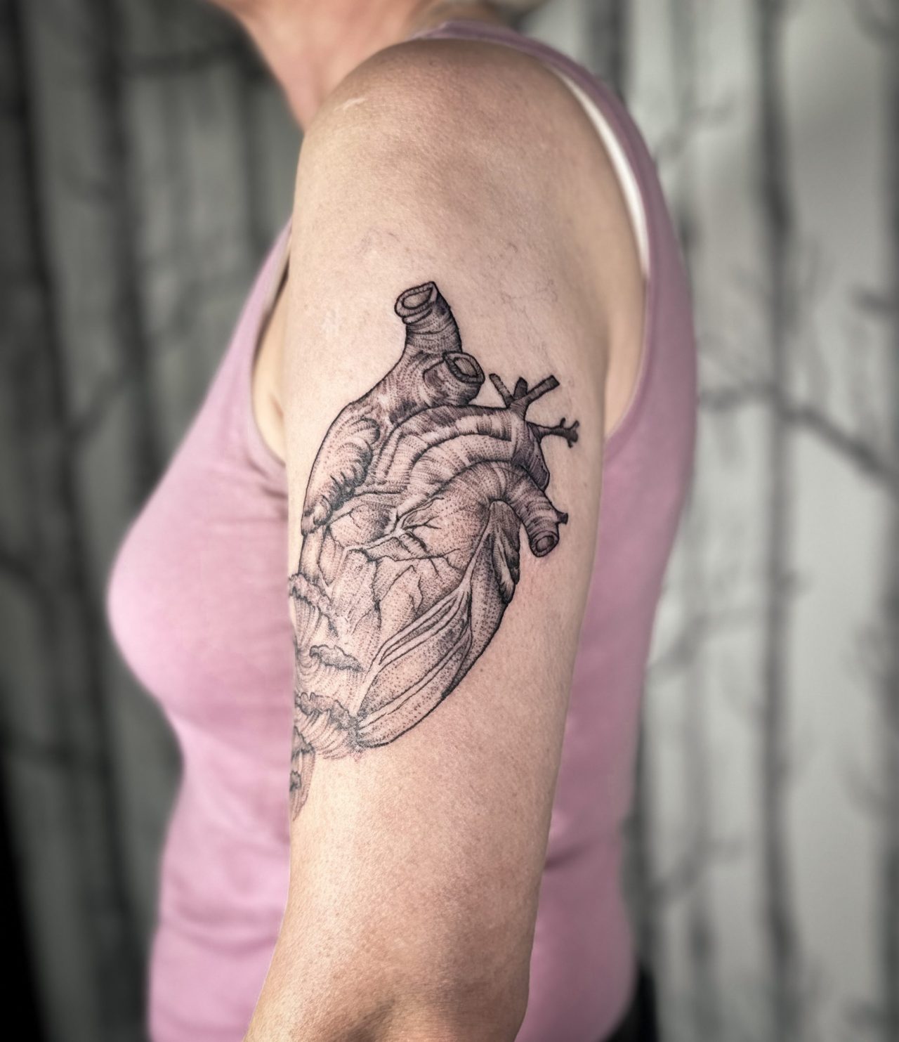 Oberarmtattoo: anatomisches Herz mit Wellen