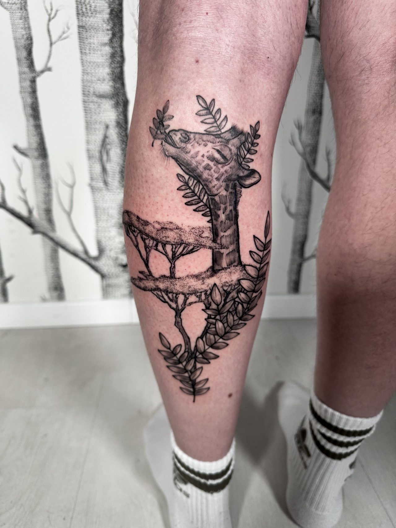 Wadentattoo: Giraffenkopf in Baumkrone