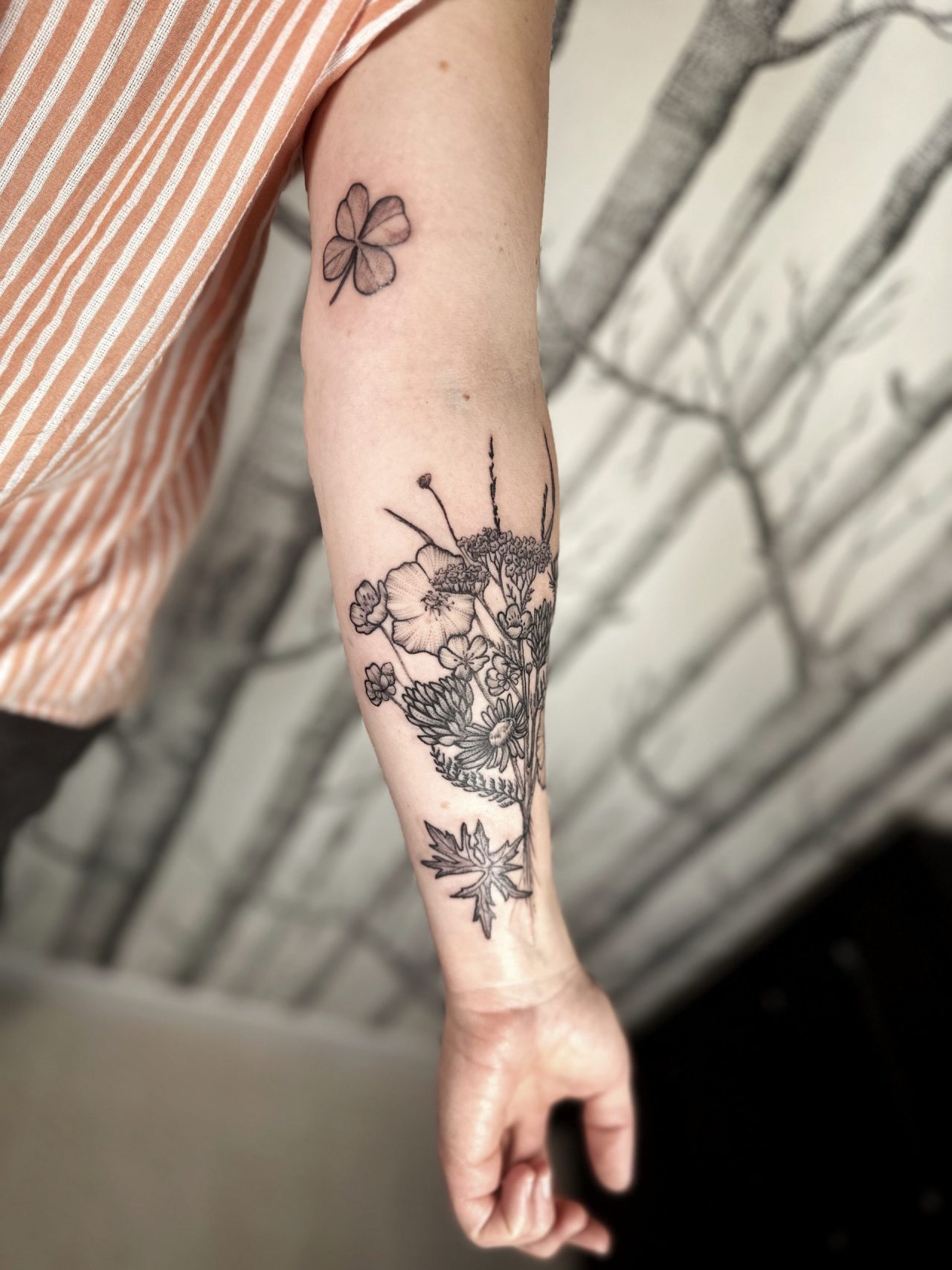 Armtattoo: Wildblumenstrauß und vierblättriges Kleeblatt