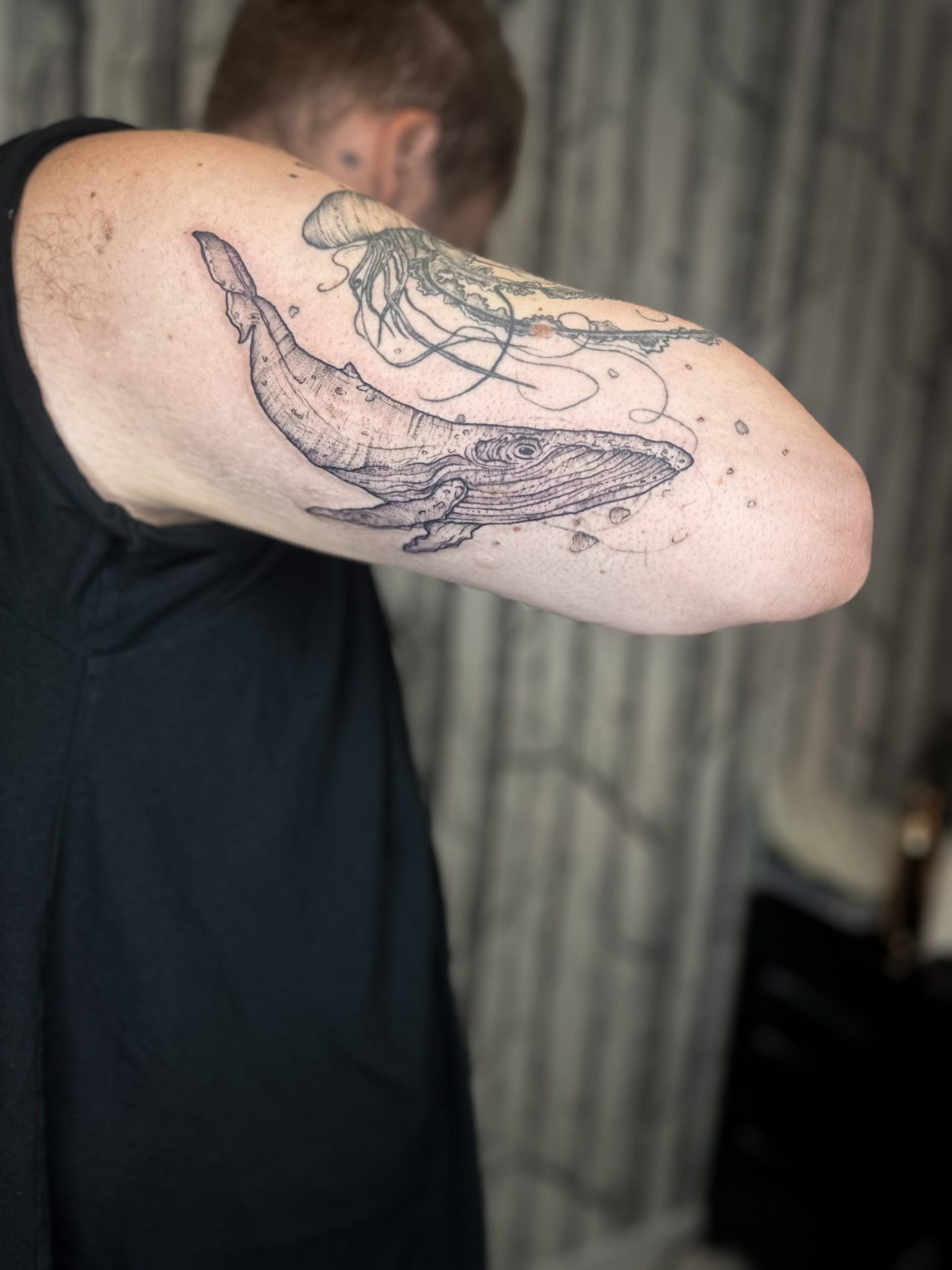 Oberarmtattoo: Wal und abgeheilte Qualle