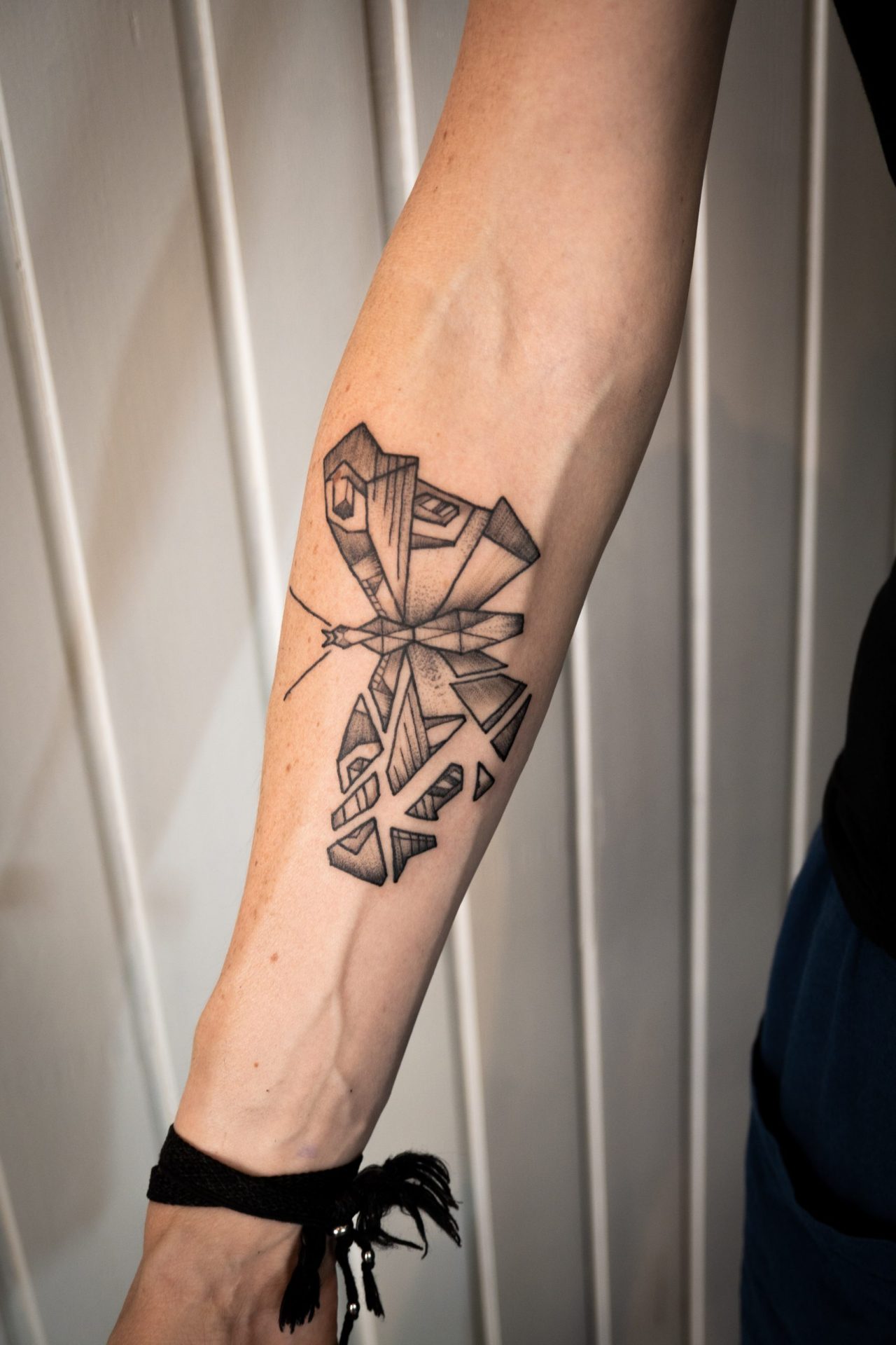 Tagpfauenauge Falter auf Unterarm, geometrisches Muster, halb ganz, halb zersplittert