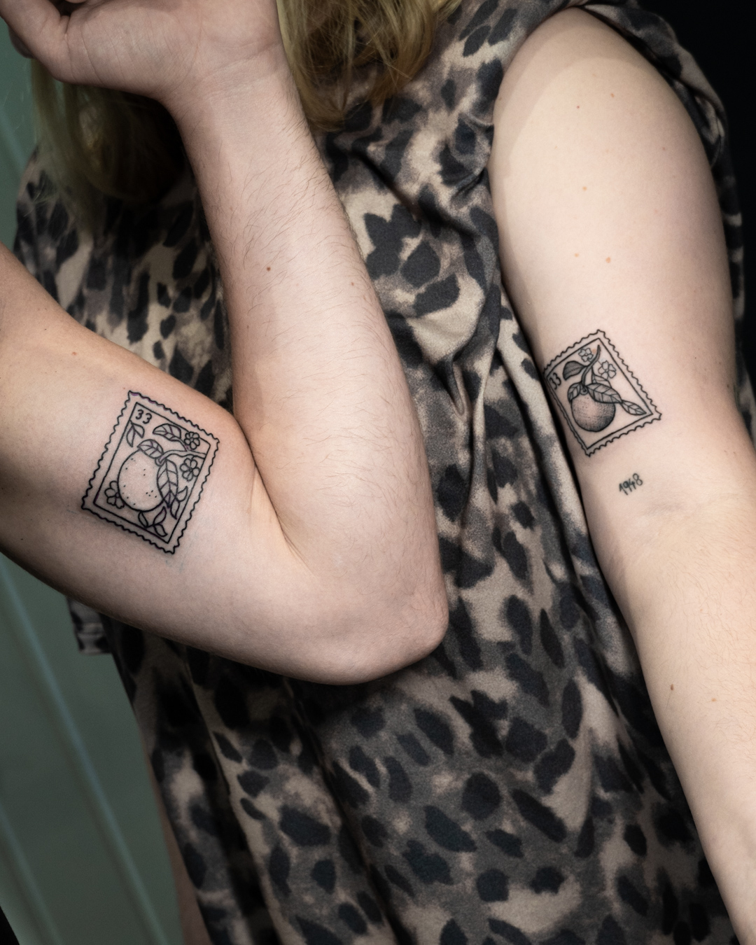 Freundschaftstattoo: zwei Briefmarken in unterschiedlichem Stil mit Orangen